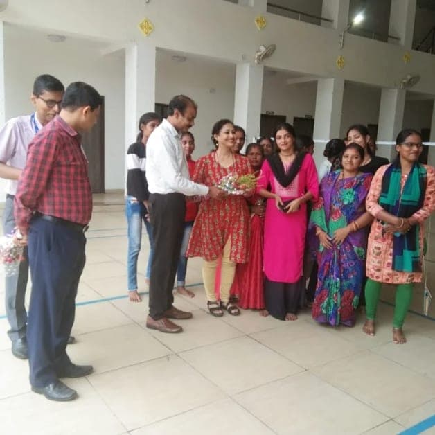 A bouquet being presented at the workshop inauguration, the group of trainees standing behind.